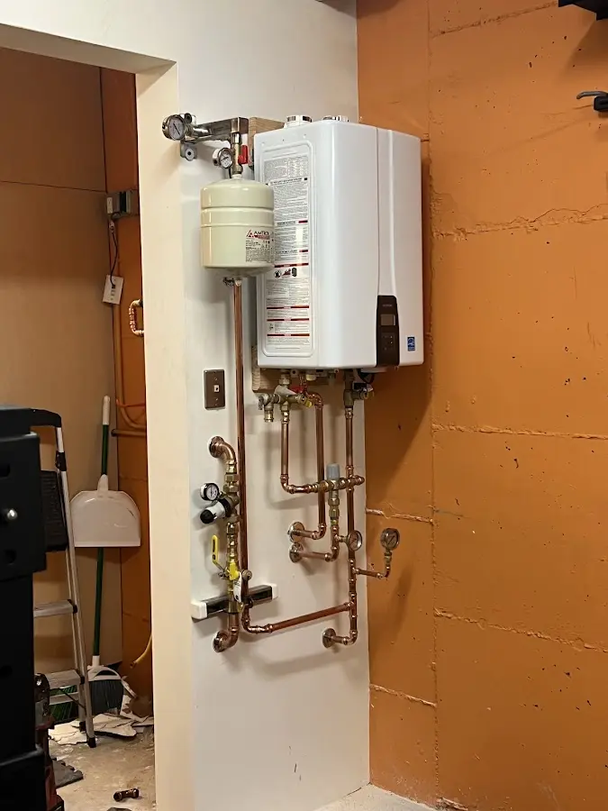 Plumbing technician inspecting water heater connections in Ashburn
